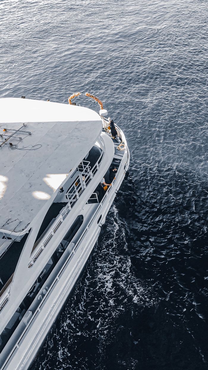 creative-01 High angle view of a white passenger ship sailing through deep blue waters, showcasing luxury travel.