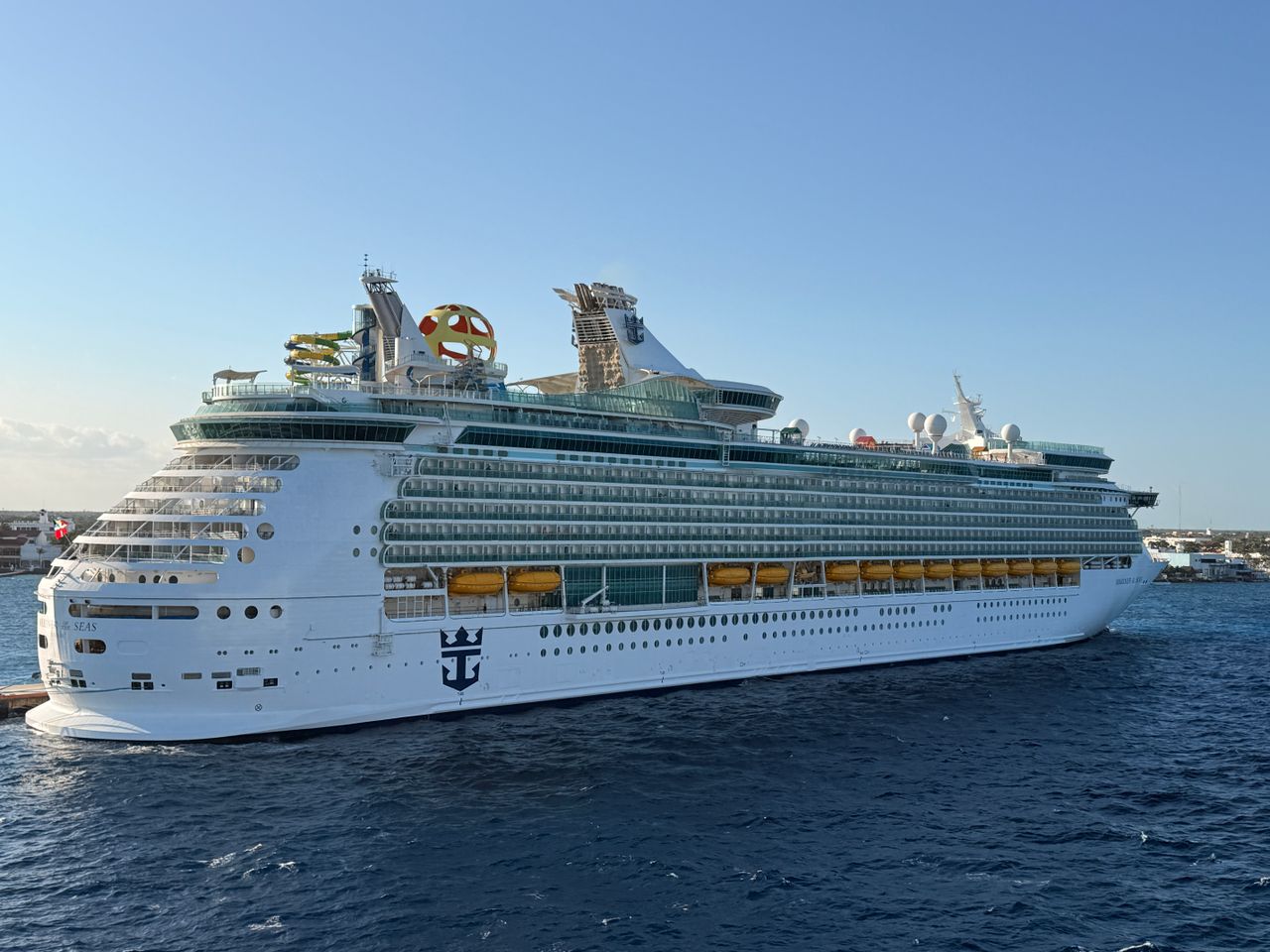 brand-01 Luxurious cruise ship docked in a sunny harbor showcasing its grandeur with blue ocean backdrop.